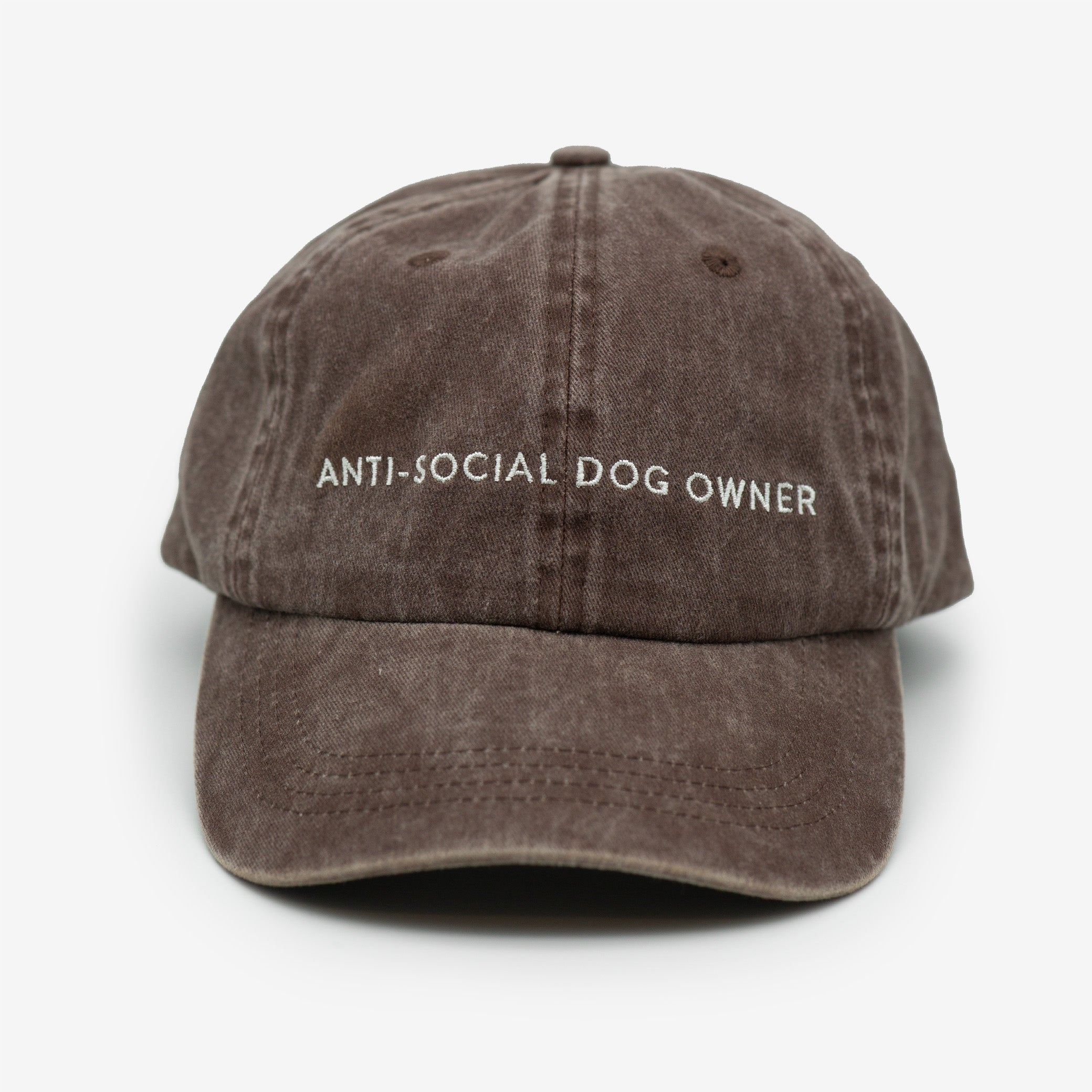 A brown denim cap with the text 'ANTI-SOCIAL DOG OWNER' embroidered on the front.